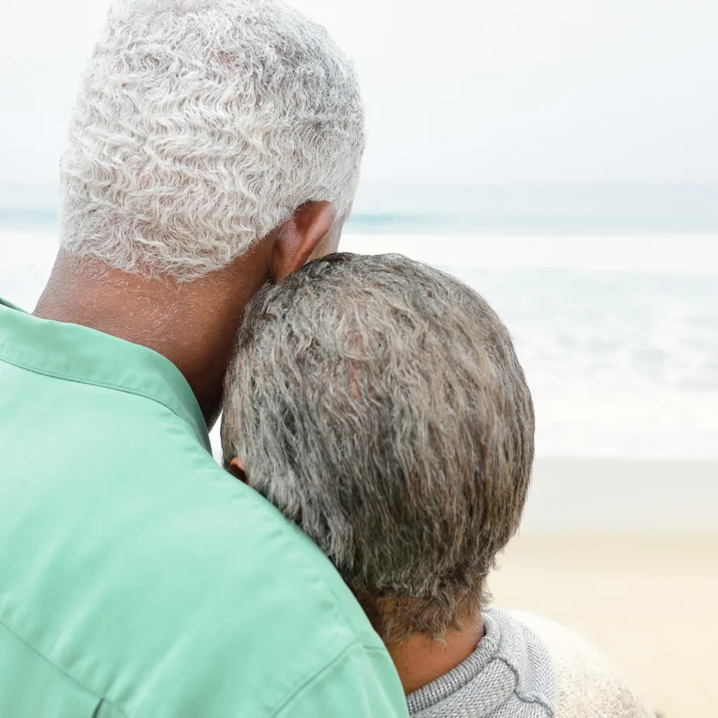 Older couple resting together at the beach