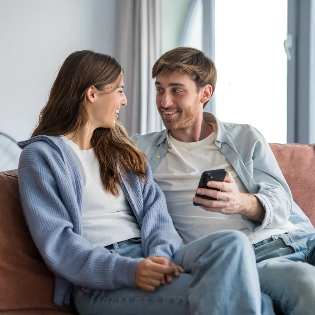 Couple smiling while both hold phones